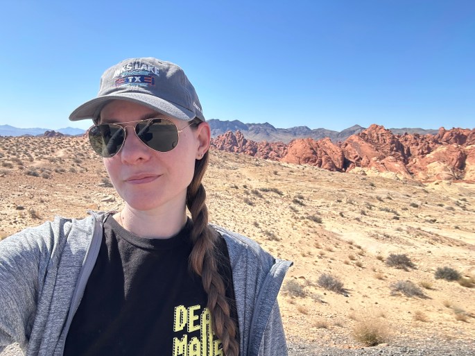 Camper wearing Texas State Parks hat in front of Fire Canyon
