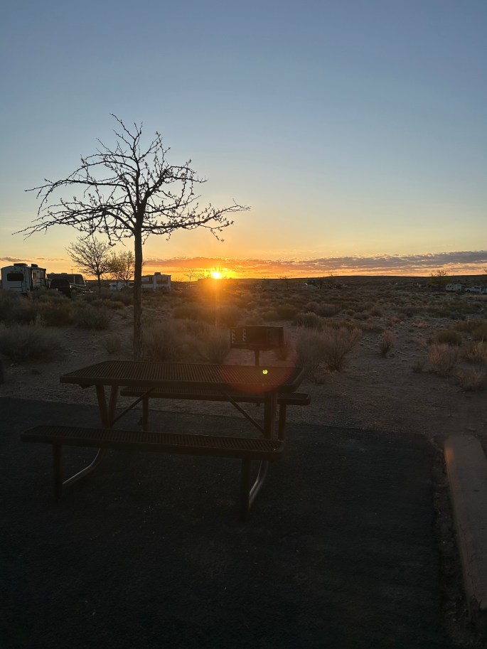 Early morning desert sunrise casting warm light over Homolovi State Park campground